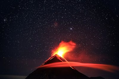 Composite volcano erupting at night